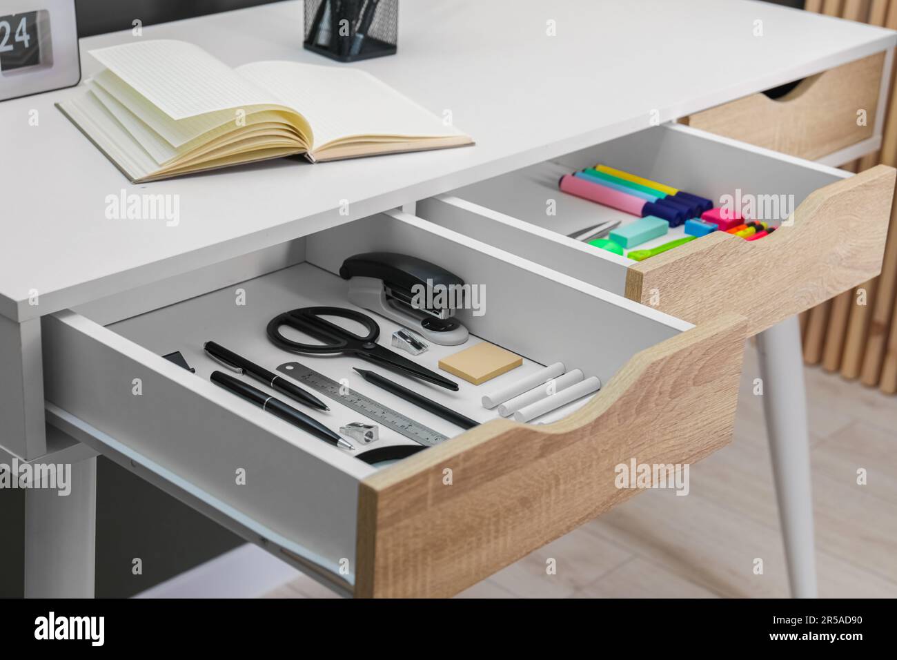 Bürobedarf in offenen Schreibtischschubladen im Innenbereich Stockfoto