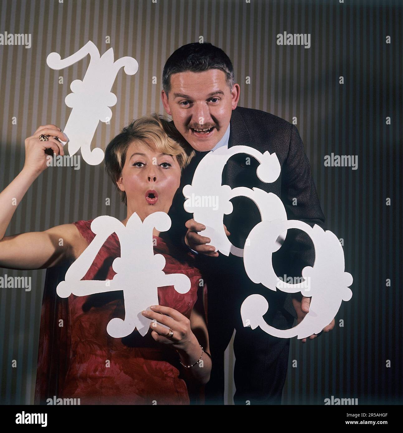 Spaß mit Zahlen in den 1960er. Eine Frau und ein Mann halten verschiedene Nummern in den Händen 1,4,6 und 9. Unklar ist, was der Zweck ist, abgesehen von der Vermutung, dass sie versuchen, sie als Jahreszahlen zusammenzufassen. Es gibt Schauspieler/Sänger Monica Zetterlund und Hans Alfredson, sehr gut bekannte schwedische Künstler. Schweden 1964 Stockfoto
