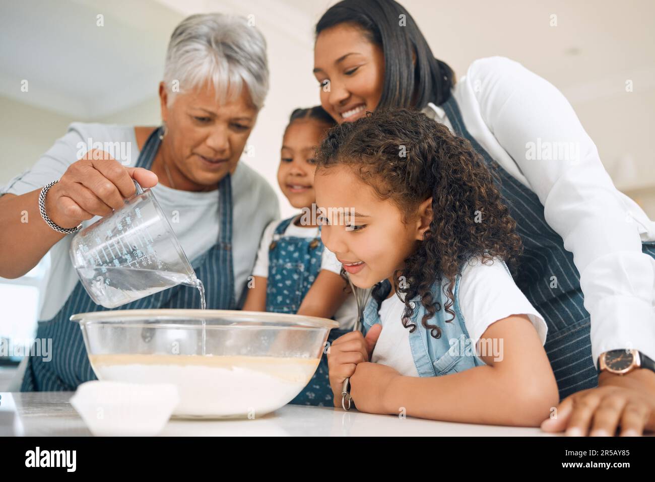 Großmutter, mutter oder Kinder in der Küche, um als glückliche Familie zu backen, wobei Geschwister Kekse lernen. Kuchen, Entwicklung oder lächelnde Oma mischen Stockfoto