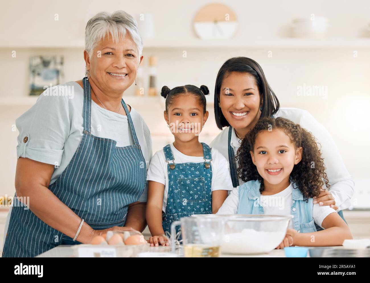 Porträt von Großmutter, mutter oder Kindern, die in der Küche backen, als glückliche Familie mit Geschwistern, die Kochkünste erlernen. Kuchen, Eltern oder Großmutter lächelnd oder Stockfoto
