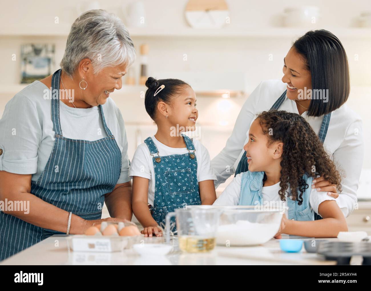 Großmutter, mutter oder glückliche Kinder, die in der Küche in einem Familienhaus backen, wobei Geschwister Kochkünste lernen. Kuchen, lachende Frau oder lächelnde Oma Stockfoto