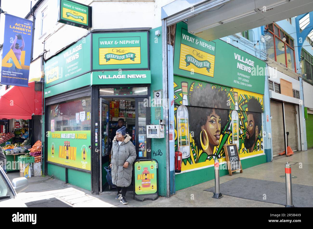 wray und Neffen werben von carlene de souza im Dorfzeitungsladen; brixton SW9 Markt mit Verkaufsständen, Restaurants, Bars usw. in der Arkade und an der Straße in lambeth london, england, Großbritannien; brixton Village Market Row und brixton Village Stockfoto