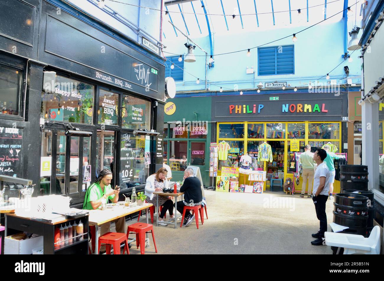 Der Joint; brixton SW9 Markt mit Verkaufsständen, Läden, Restaurants, Bars usw. in der Arkade und an der Straße in lambeth london england, Großbritannien; brixton Village Market Row und brixton Village Stockfoto