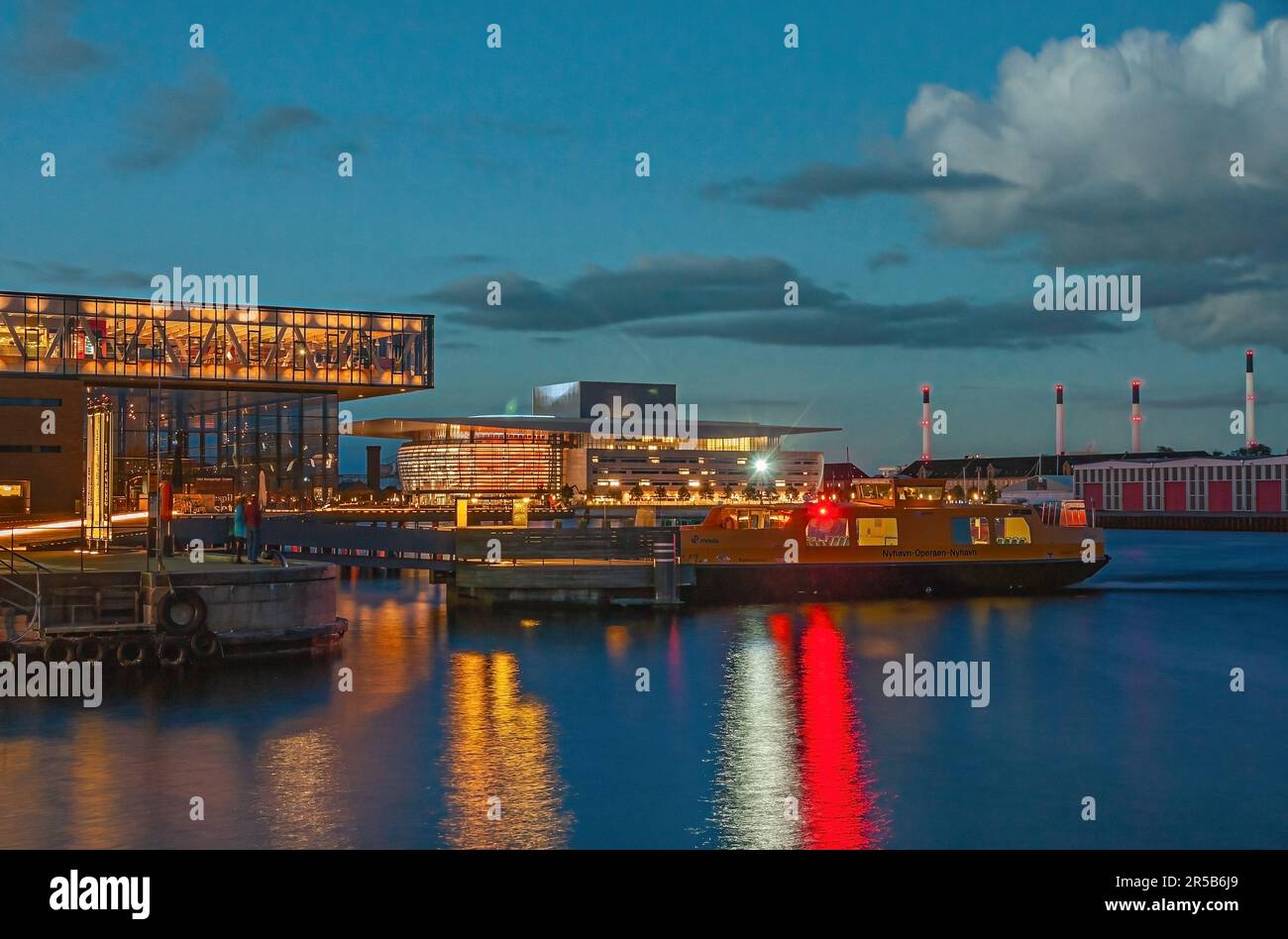 Kopenhagen, Dänemark - 13. September 2010: Spätabendlicher Blick über den Hafen mit königlichem Theater in der Ecke, Fähre auf dem Hafenwasser und Opernhaus in B Stockfoto