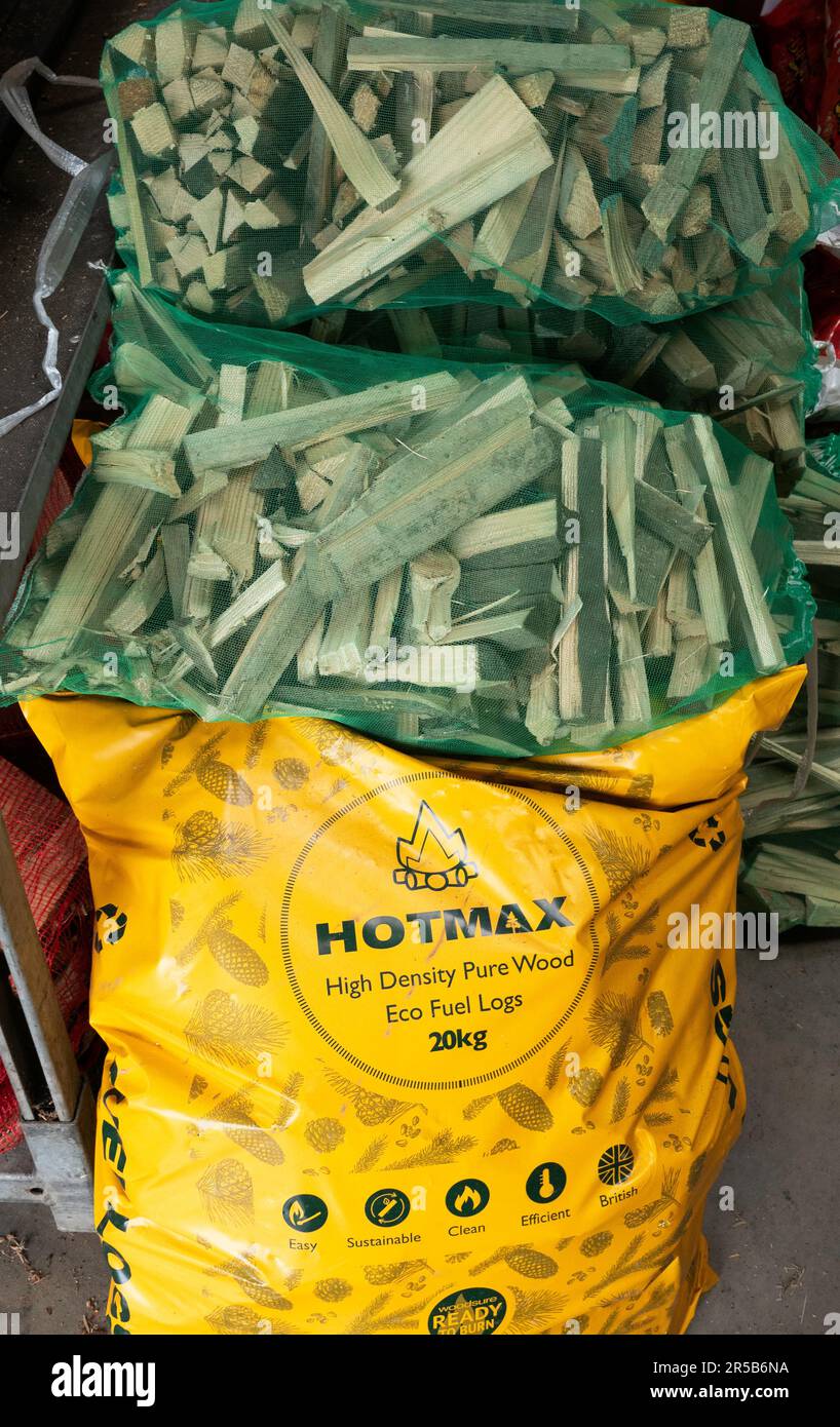 Für die Beheizung von Privathaushalten 20kg Beutel mit hochdichten Öko-Brennstämmen aus reinem Holz von Hotmax mit Säcken aus Brennholz in einem Yorkshire Farm Shop Stockfoto