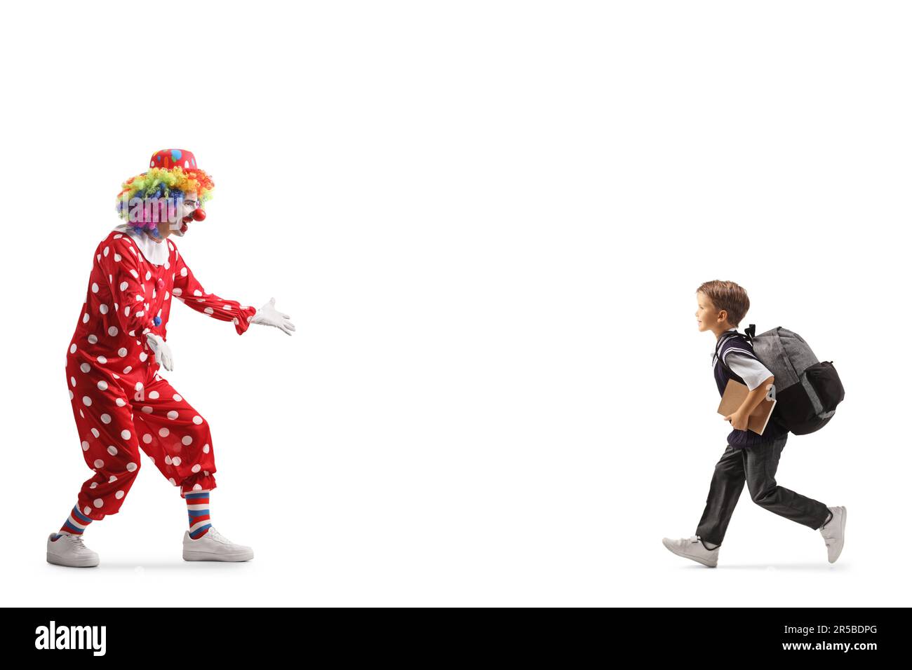 Profilaufnahme eines Schuljungen, der einen Clown umarmt, isoliert auf weißem Hintergrund Stockfoto