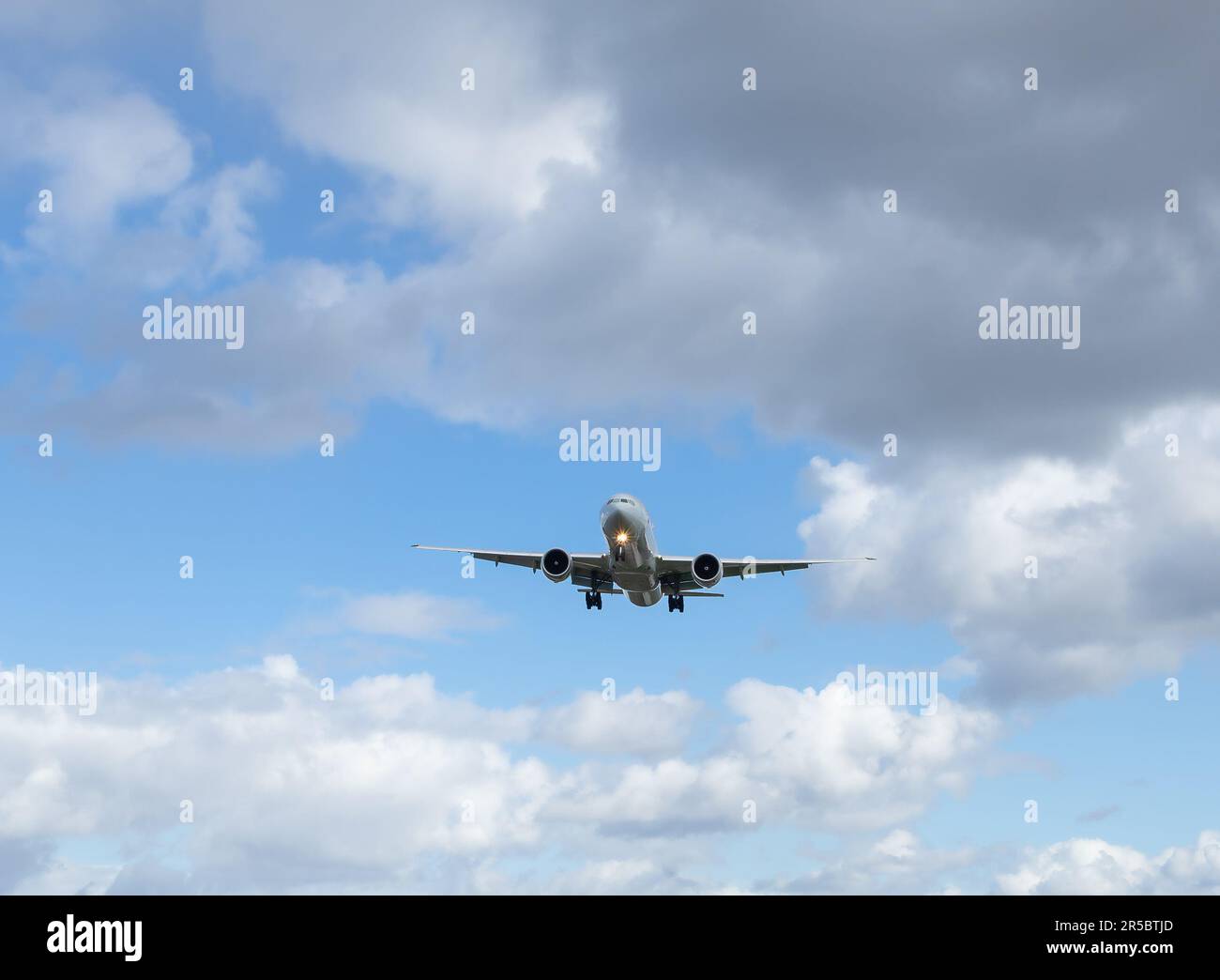 Passagierflugzeug fliegt vor dem Hintergrund eines blauen Himmels mit Wolken. Fahrt im Erwachsenenfahrzeug Stockfoto