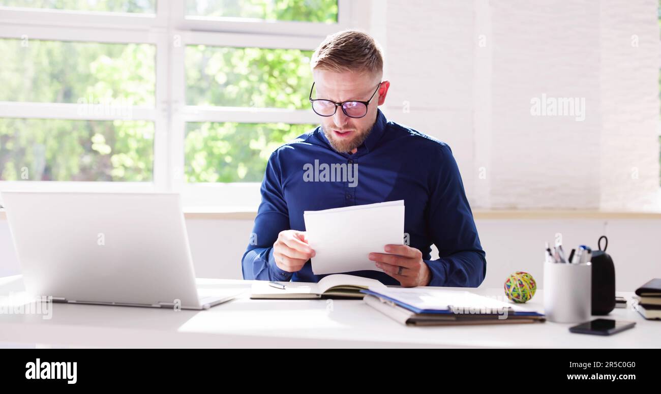 Trauriger Mann Liest Papierrechnung Mit Stress Stockfoto