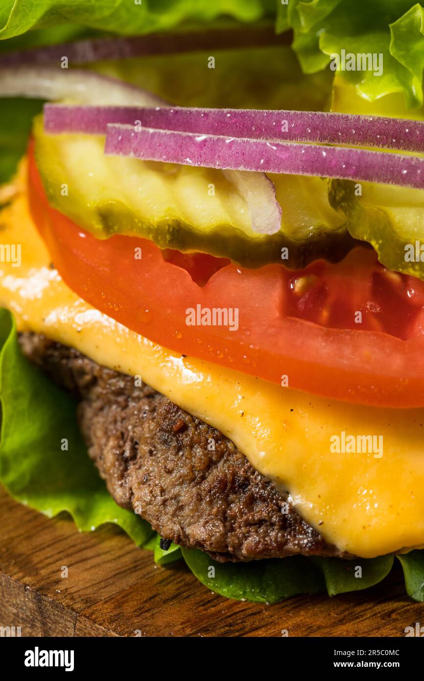 Glutenfreier Paleo Bunless Cheeseburger mit Salat und Tomate Stockfoto