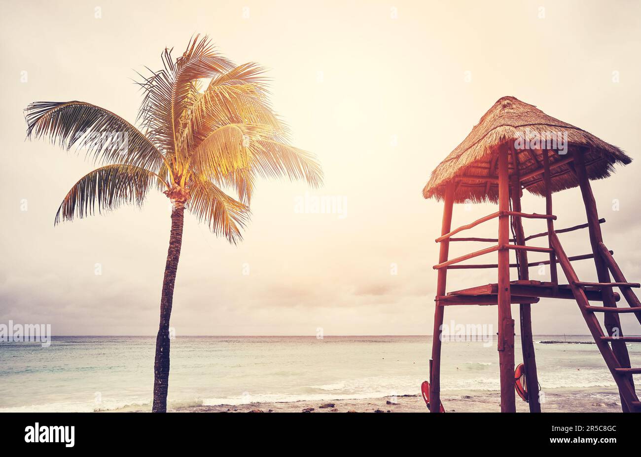 Retro-Farbfoto eines tropischen Strands als Sonnenuntergang, Sommerferienkonzept. Stockfoto