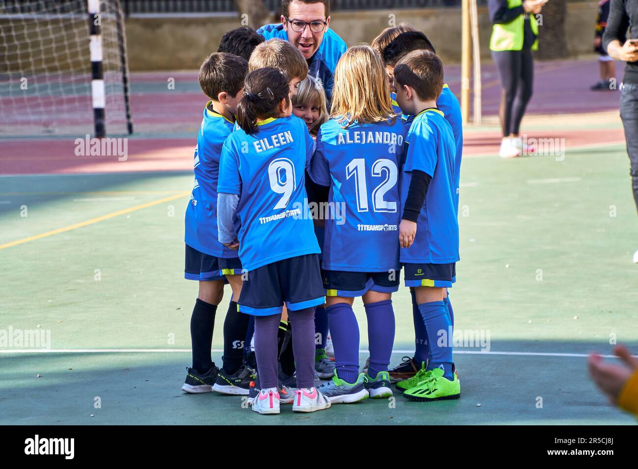 Fußballmannschaft für Kinder, die sich mit ihrem Trainer anspornt Stockfoto