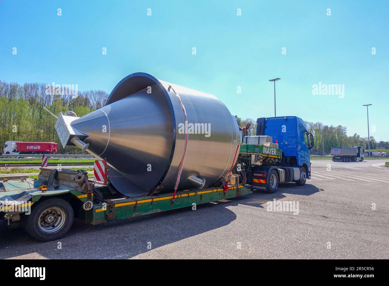 AACHEN, NRW, DEUTSCHLAND - 18. April 2019: Schwertransport eines großen Edelstahlbehälters auf einem Tieflader-Anhänger, Parken an einer Lkw-Haltestelle Stockfoto