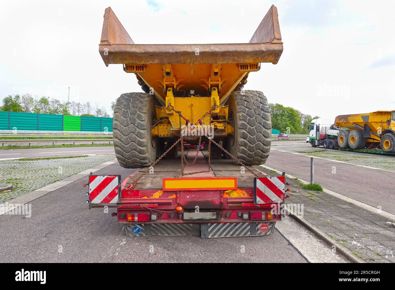 Big Truck mit niedriger Plattform Anhänger mit einem Kipper auf einem öffentlichen Parkplatz von einem Truck Stop. Stockfoto