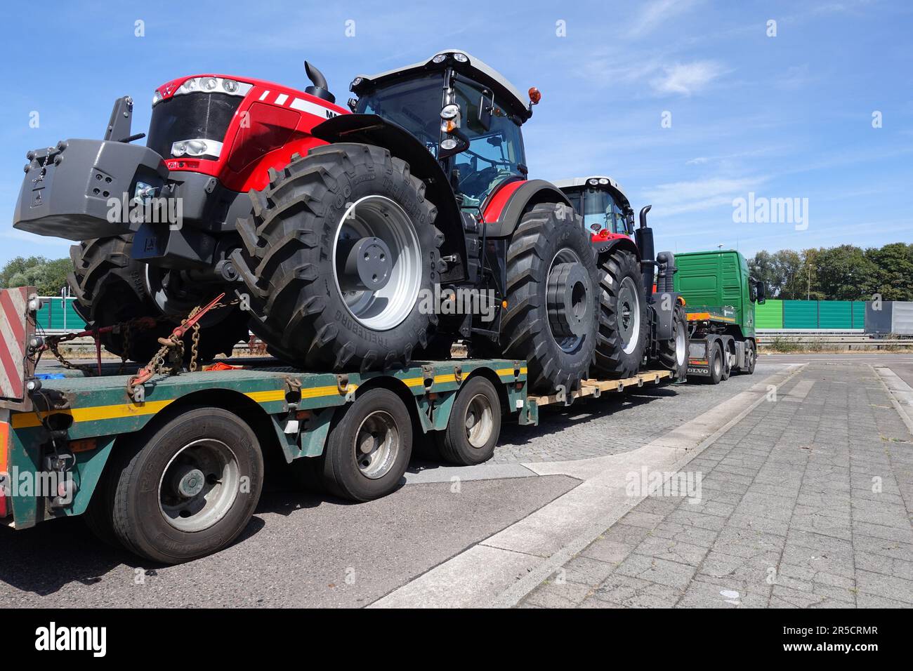 AACHEN, NRW, DEUTSCHLAND - 27. JULI 2018: Schwertransporte von großen Traktoren auf einem speziellen Tieflader-Lkw, Straßenparkplatz auf einer Autobahn. Stockfoto