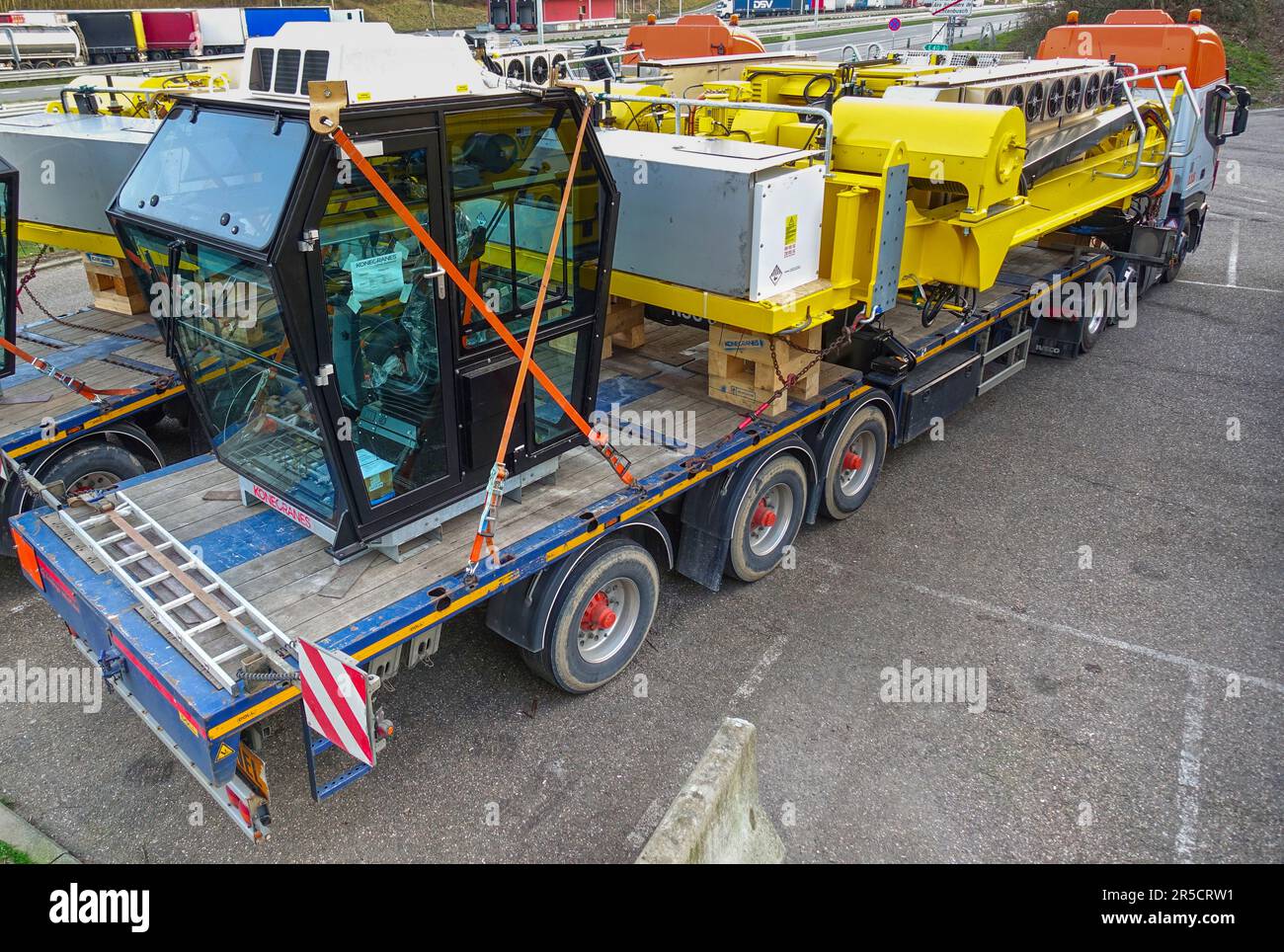 Lichtenbusch, Wallonien, Belgien – 18. März 2020: Großer Lkw mit Plattformanhänger, der Teile eines uge-Krans auf einer Lkw-Haltestelle transportiert Stockfoto