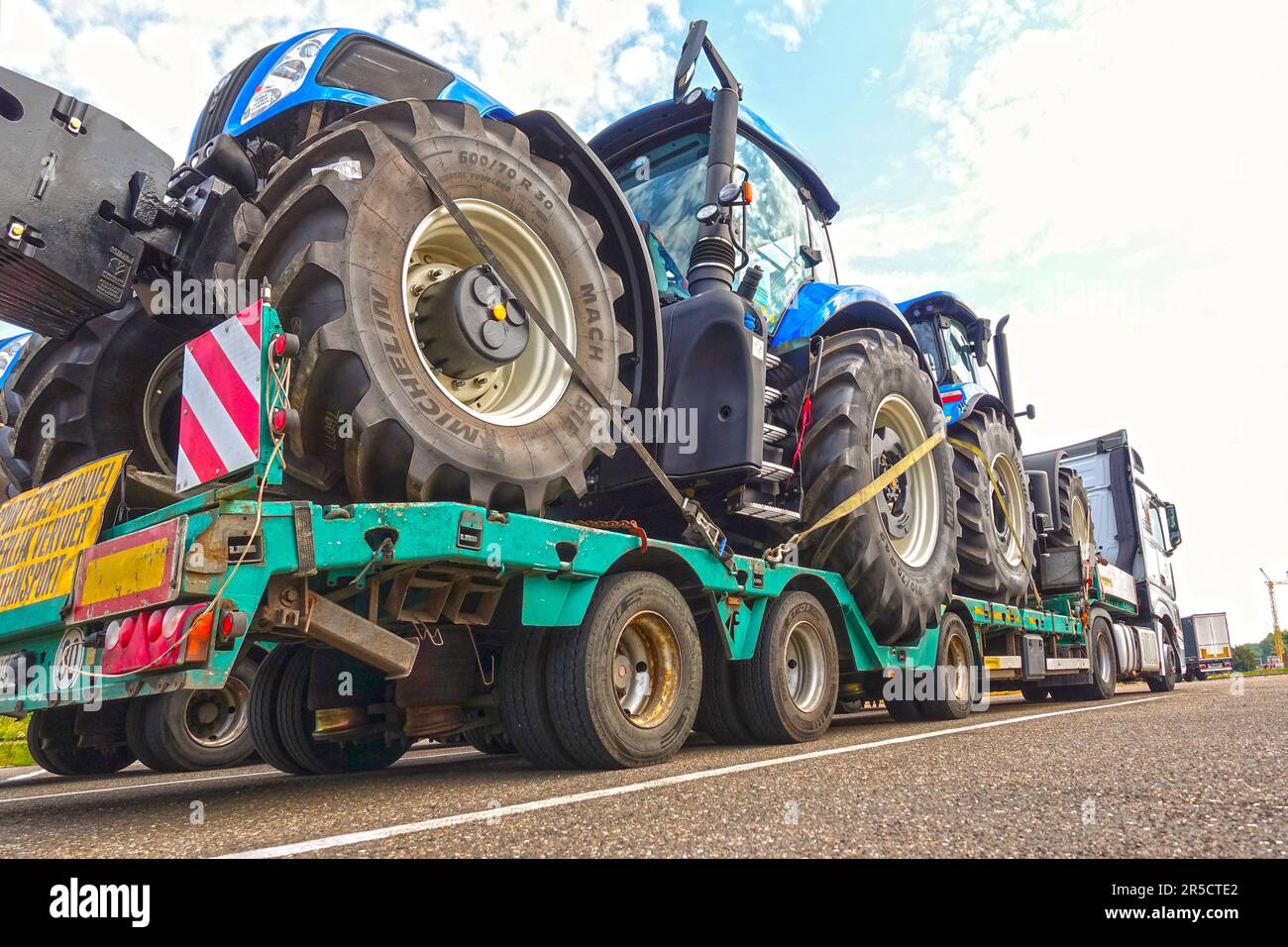 AACHEN, NRW - 12. Juli 2019: Schwertransport großer Traktoren auf einem speziellen Tieflader-Anhänger-LKW, Parkplatzsicht auf einer Autobahn. Stockfoto