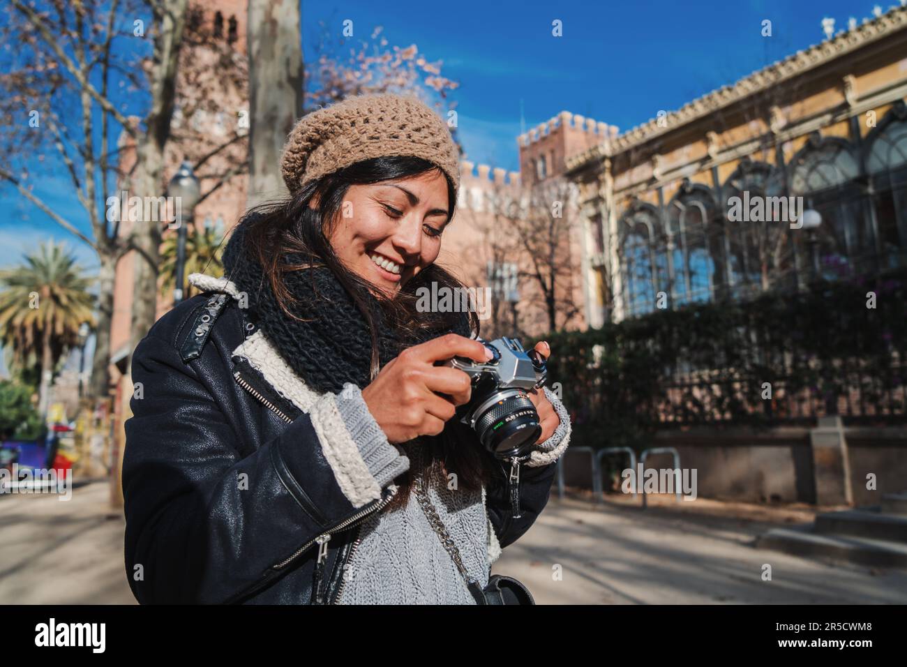 Glückliche junge Frau, die auf einer Jouney-Reise Fotos im Urlaub macht. Süße Touristenfotografin, die auf dem Bildschirm der Kamera das Foto sieht, das sie gerade auf einer Spanienreise aufgenommen hat. Hochwertiges Foto Stockfoto