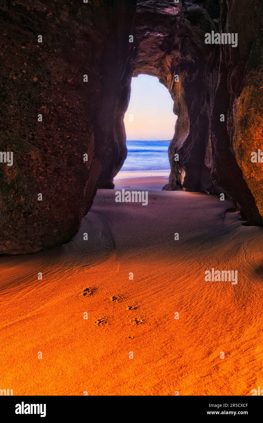 Malerische Meereshöhle am Caves Beach pazifikküste bei Sonnenaufgang bis hin zum glatten Sandstrand in Australien. Stockfoto
