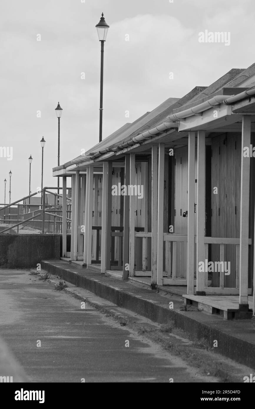 Vertikale monochrome Aufnahme alter Holzhütten am Meer. Stockfoto