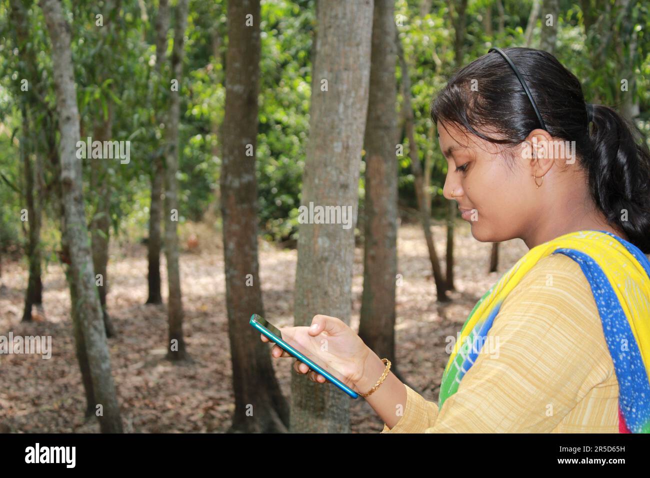 Lächelndes asiatisch-indianisches Mädchen macht ein Selfie im Freien Stockfoto
