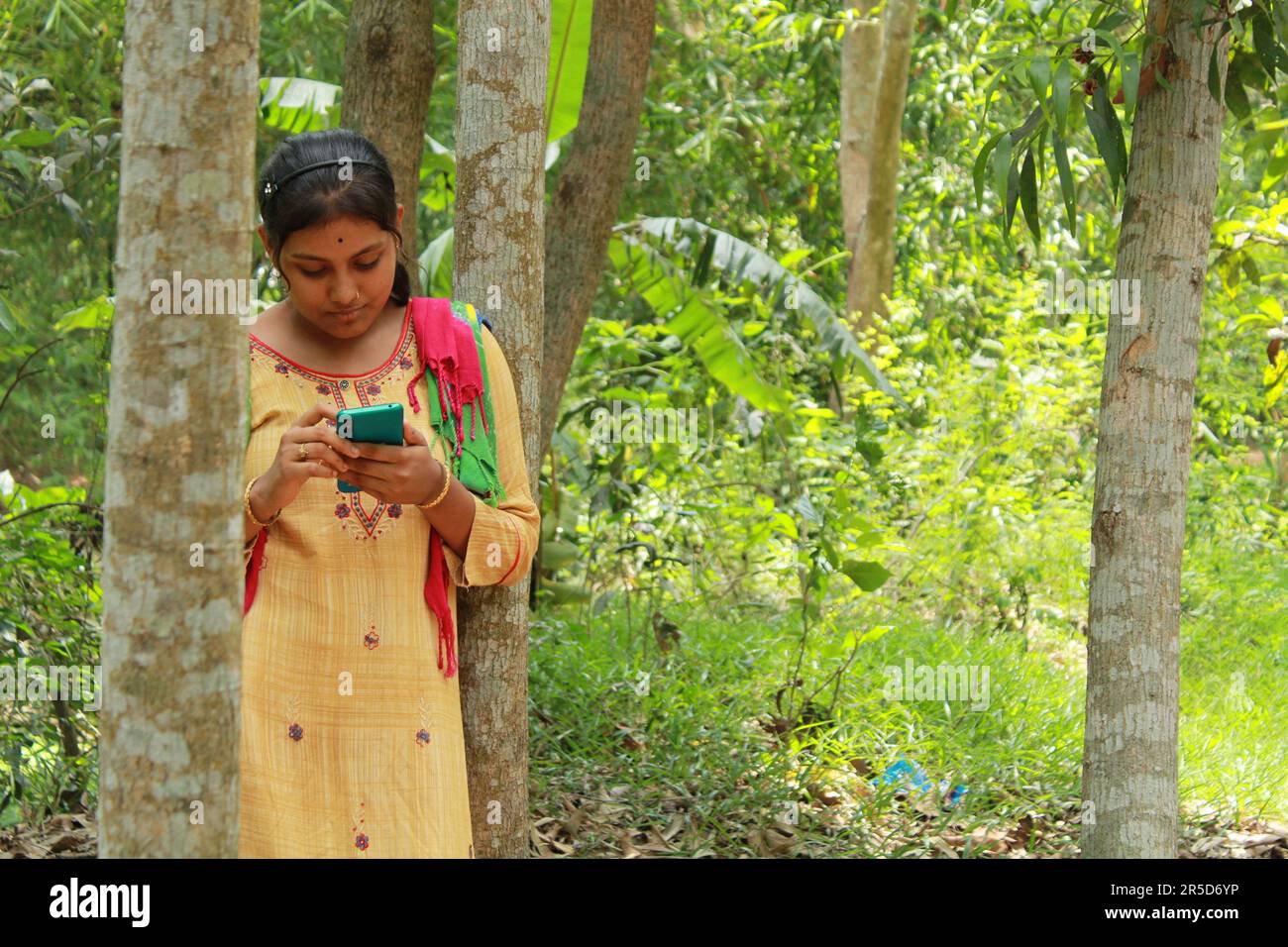 Lächelndes asiatisch-indianisches Mädchen macht ein Selfie im Freien Stockfoto