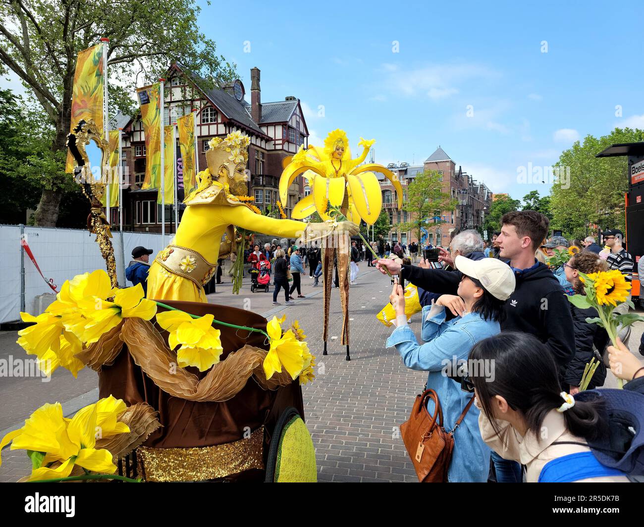 Amsterdam, Niederlande. 02. Juni 2023. Ein Schauspieler verteilt Sonnenblumen an Besucher während festlicher Aktivitäten zur Erinnerung an den 50. Jahrestag des Van Gogh Museums auf dem Museumsplatz in Amsterdam, Niederlande, am 2. Juni 2023. Das Van Gogh Museum hat hier eine Reihe festlicher Aktivitäten veranstaltet, um seinen 50. Jahrestag zu feiern und das Erbe von Vincent van Gogh, einem der berühmtesten und erfolgreichsten niederländischen Künstler, zu ehren. Zu Ehren von Vincent van Goghs Leben und künstlerischen Werken öffnete das Van Gogh Museum erstmals am 2. Juni 1973 seine Tür. Kredit: Xinhua/Alamy Live News Stockfoto