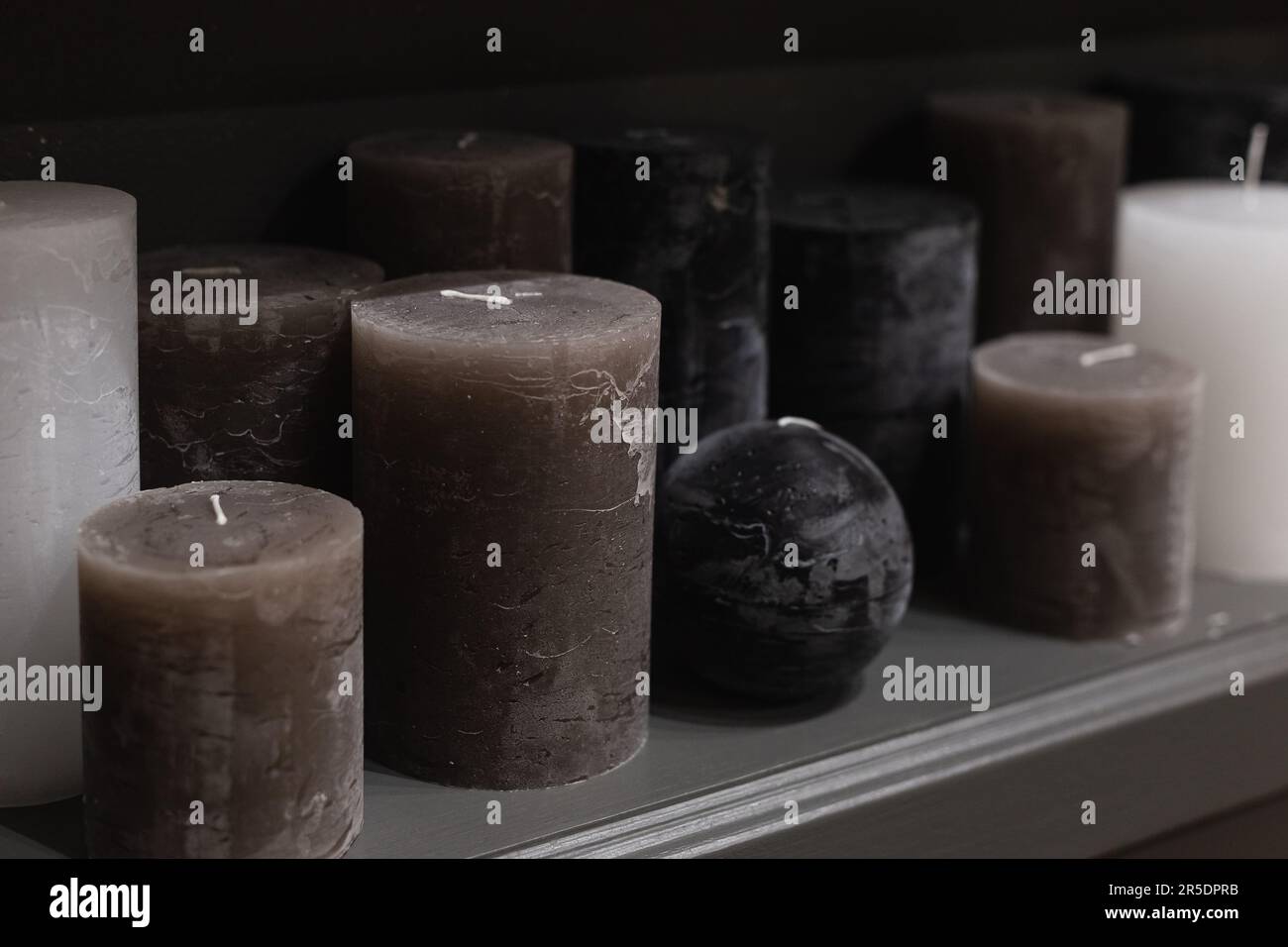 Dunkelgraue und schwarze Paraffinkerzen im Regal im Kerzenladen Stockfoto