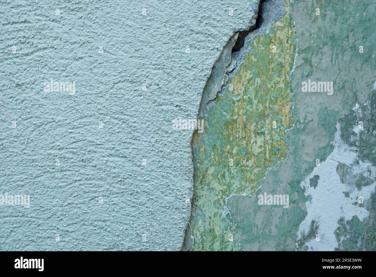 Hintergrund einer alten grünen Wand mit zusammengefallenem Putz und großem Riss. Struktur der schäbigen verwitterten Gebäudeoberfläche. Zerstörte Wand mit heruntergefallenem Gips. C Stockfoto Hintergrund einer alten grünen Wand mit zusammengefallenem Putz und großem Riss. Struktur der schäbigen verwitterten Gebäudeoberfläche. Zerstörte Wand mit heruntergefallenem Gips. C Stockfoto