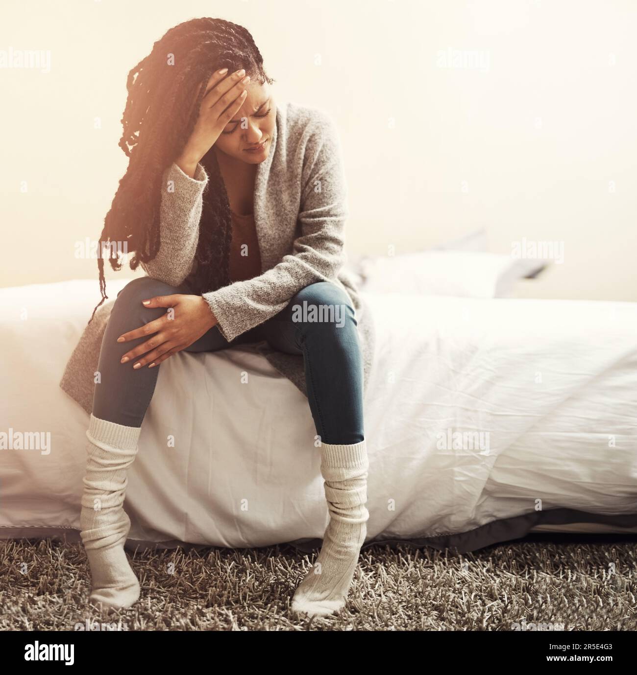Ich bin es so leid, mich als Letzter zu betrachten. Eine junge Frau, die deprimiert aussah, während sie auf ihrem Bett saß. Stockfoto