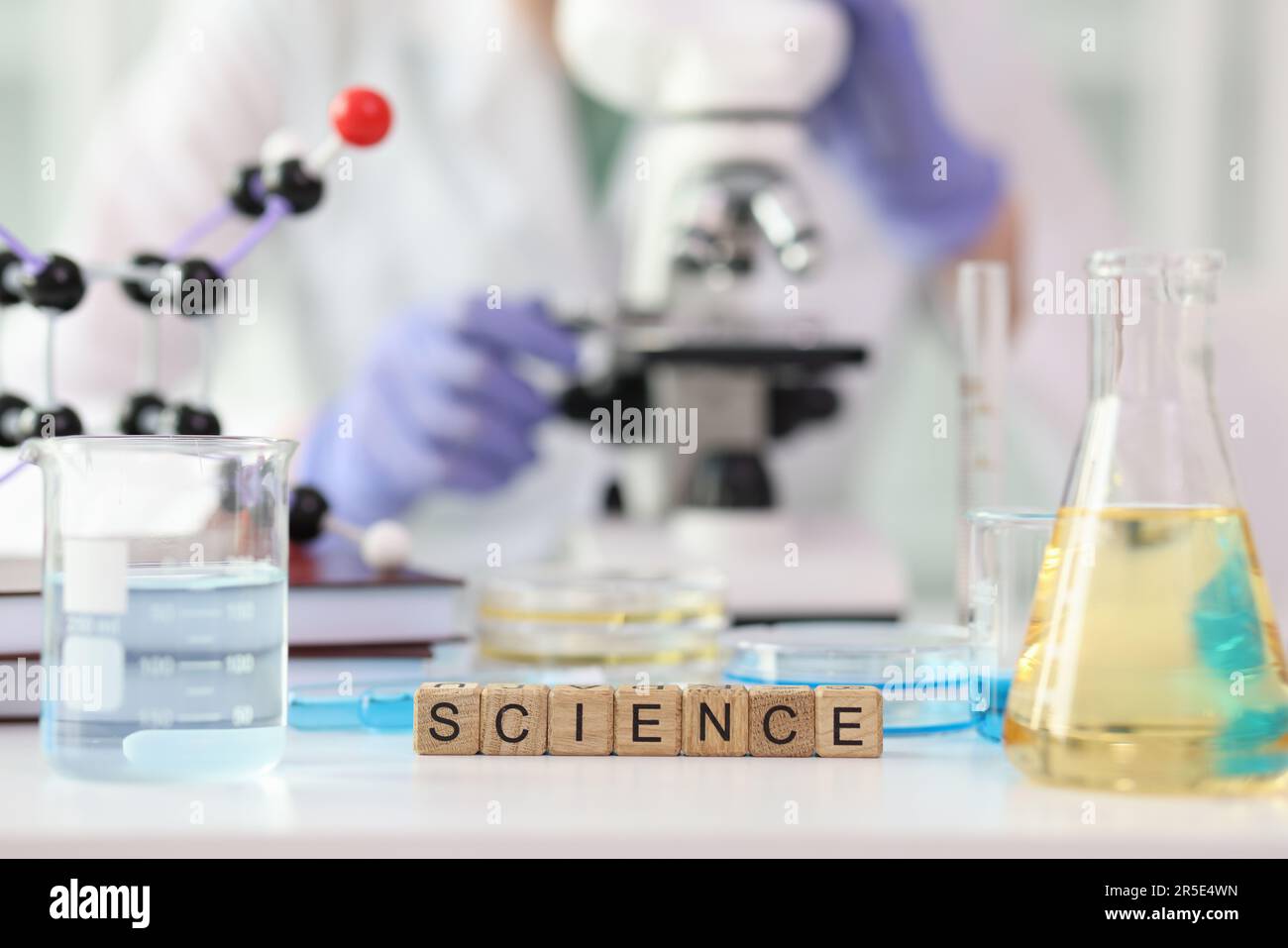 Word Science aus Würfeln in der Nähe von Laborgeräten Stockfoto