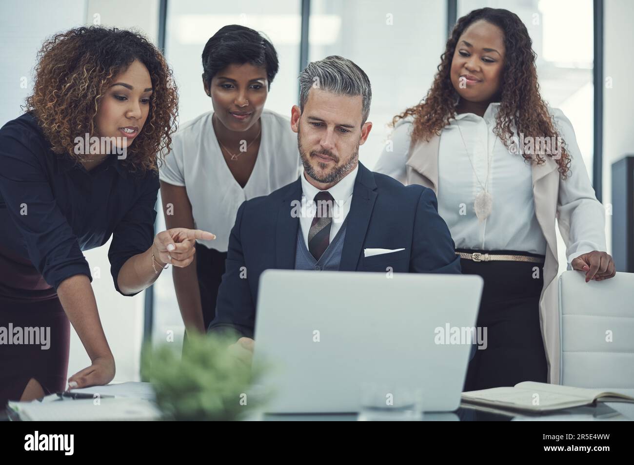 Sie tragen alle zu einer erfolgreichen Zusammenarbeit bei. Eine Gruppe von Kollegen, die gemeinsam ein Notebook in einem modernen Büro verwenden. Stockfoto