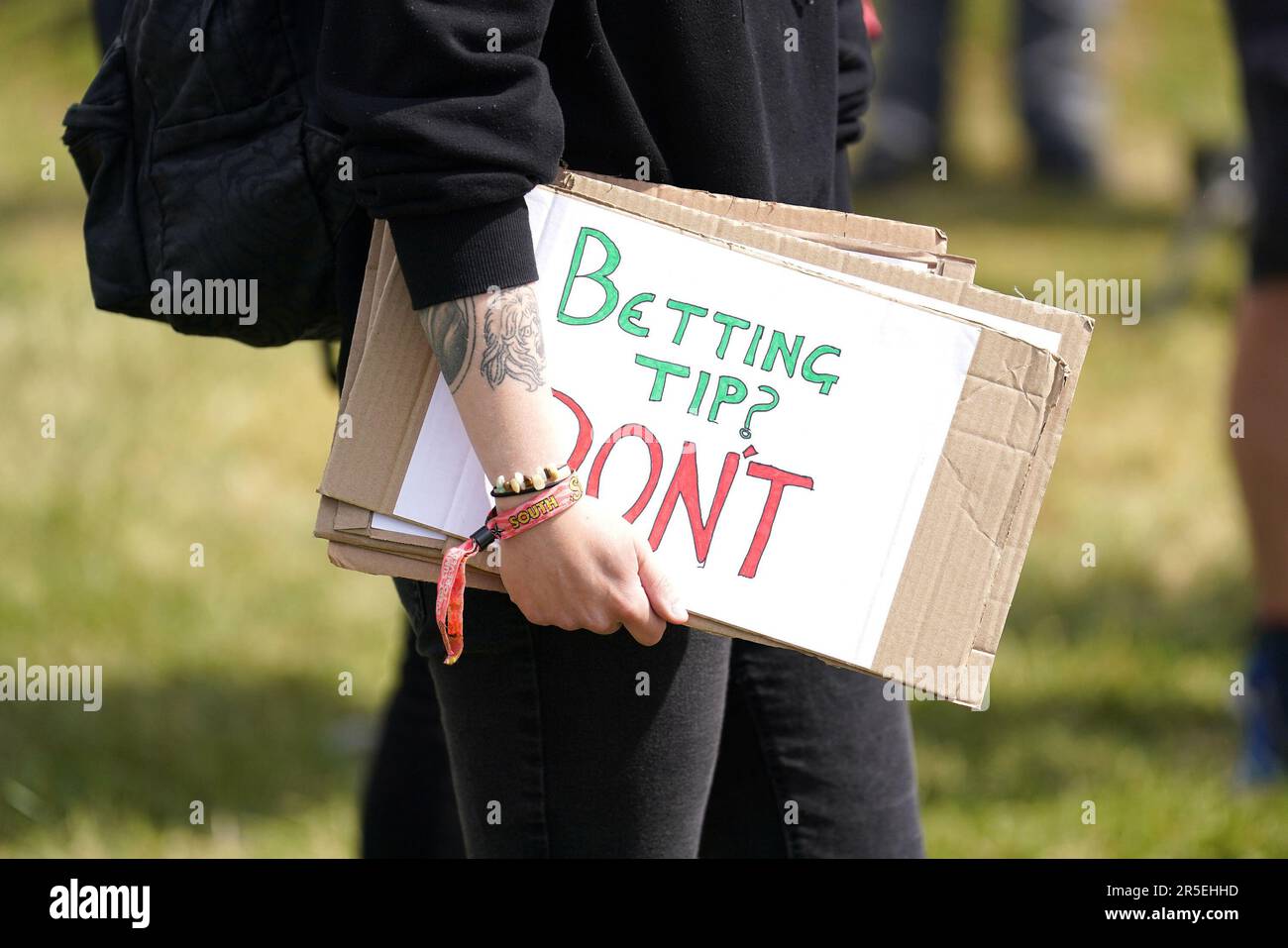 Ein Mitglied der Tierschutzorganisation Animal Rising hält ein Schild, nachdem ihnen vom Jockey Club ein Platz zugewiesen wurde, in der Nähe des Eingangs der Rennbahn, um während des Derby Festivals auf der Epsom Downs Rennbahn, Epsom, zu demonstrieren. Foto: Samstag, 3. Juni 2023. Stockfoto