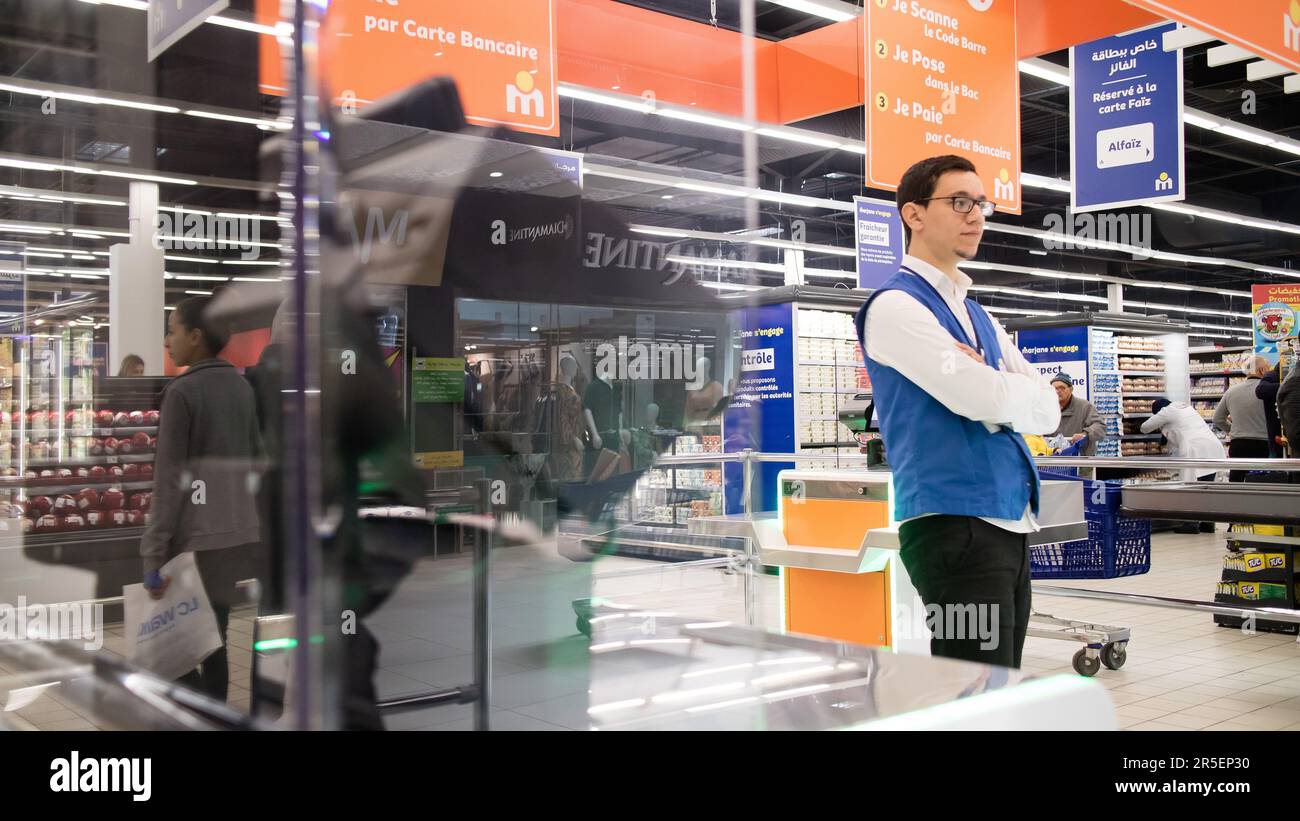 Das Personal im Supermarkt hilft den Kunden beim Self-Checkout Stockfoto
