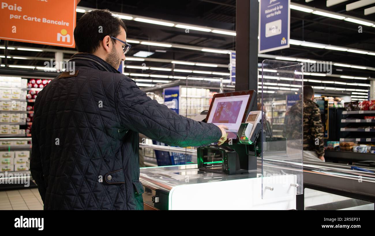 Kunde bezahlt mit Kreditkarte an einer Self-Checkout-Station in einem Supermarkt Stockfoto