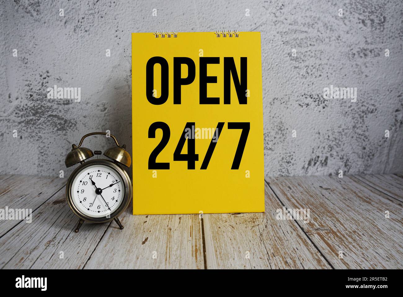 24 Stunden Geöffnet. Textnachricht und Wecker mit 7-tägigem Service auf  Holzhintergrund Stockfotografie - Alamy