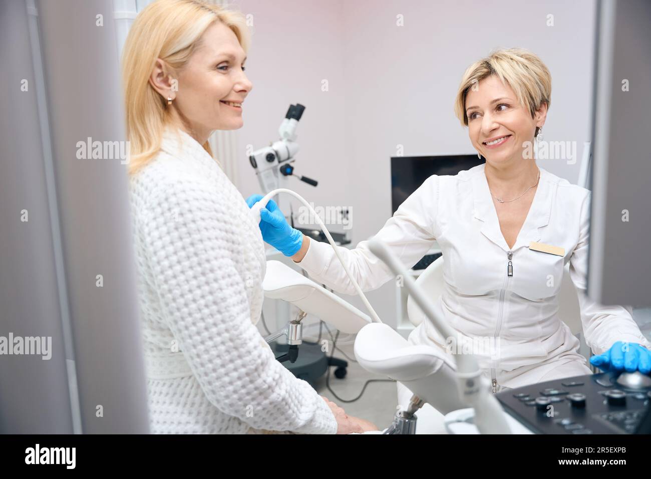 Patientin und Gynäkologe lächeln bei der Untersuchung der Brustdrüsen Stockfoto