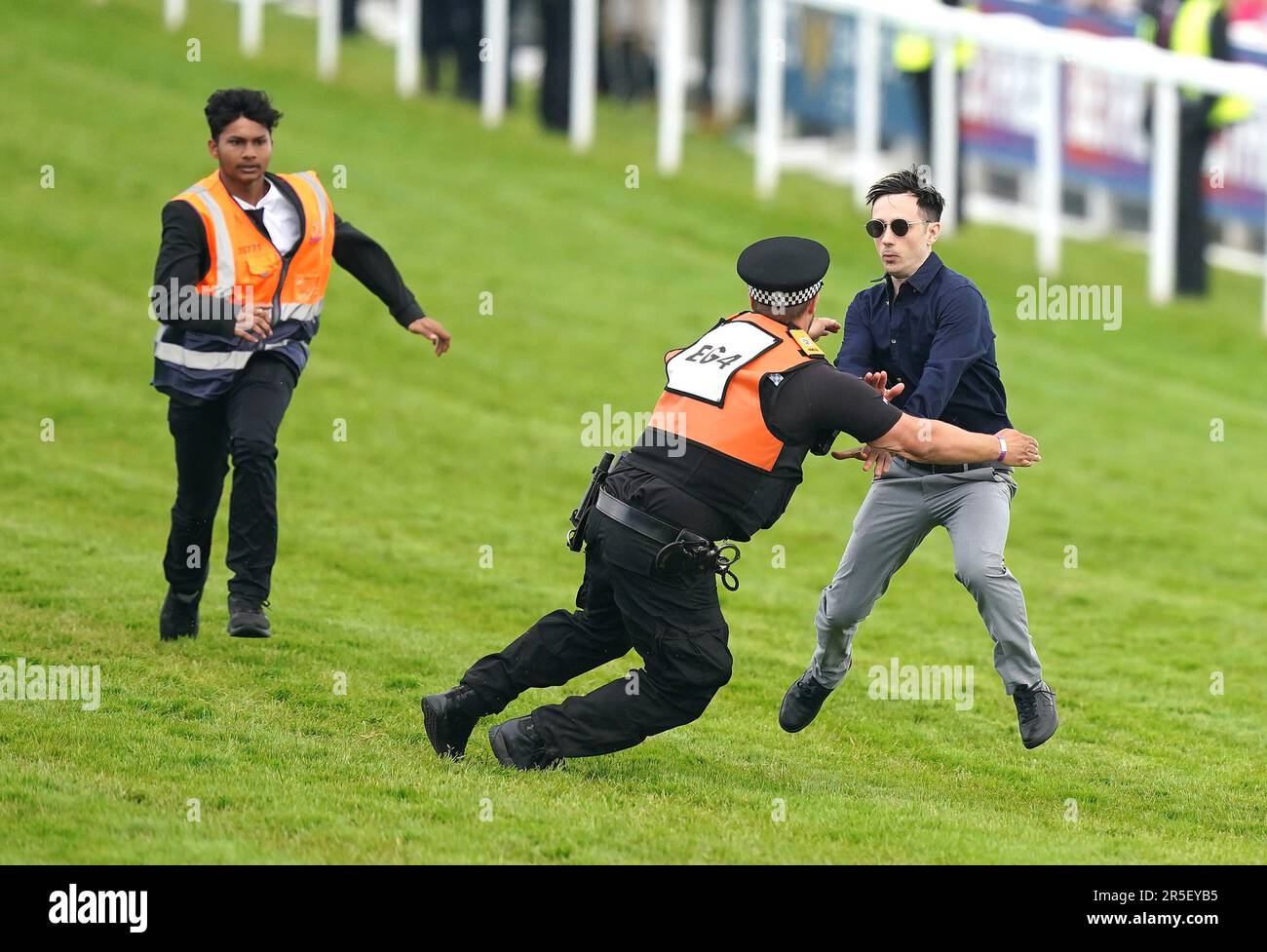 Während des Derby Day des 2023 Derby Festivals auf der Epsom Downs Racecourse, Epsom, werden Polizei und Stewards gegen einen Demonstranten protestieren. Foto: Samstag, 3. Juni 2023. Stockfoto
