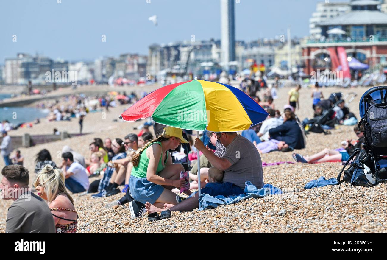 Brighton UK 3. Juni 2023 - Zeit, den Sonnenschirm rauszuholen, um an einem anderen heißen, sonnigen Tag in Brighton Schatten zu bekommen : Credit Simon Dack / Alamy Live News Stockfoto