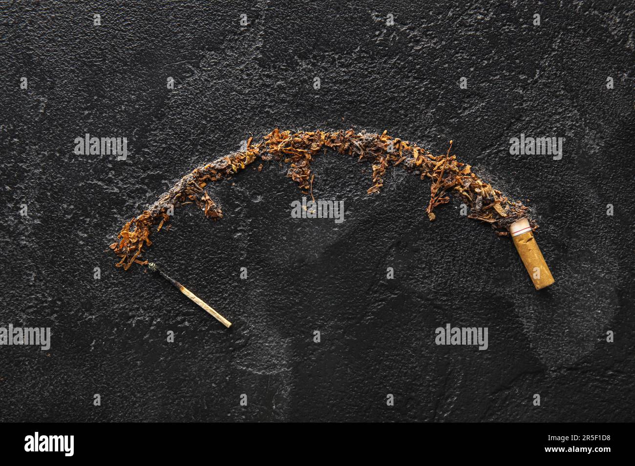 Zusammensetzung mit Zigarettenkippe, Tabak und verbranntem Streichholz auf dunklem Hintergrund. Rauchverbot-Konzept Stockfoto