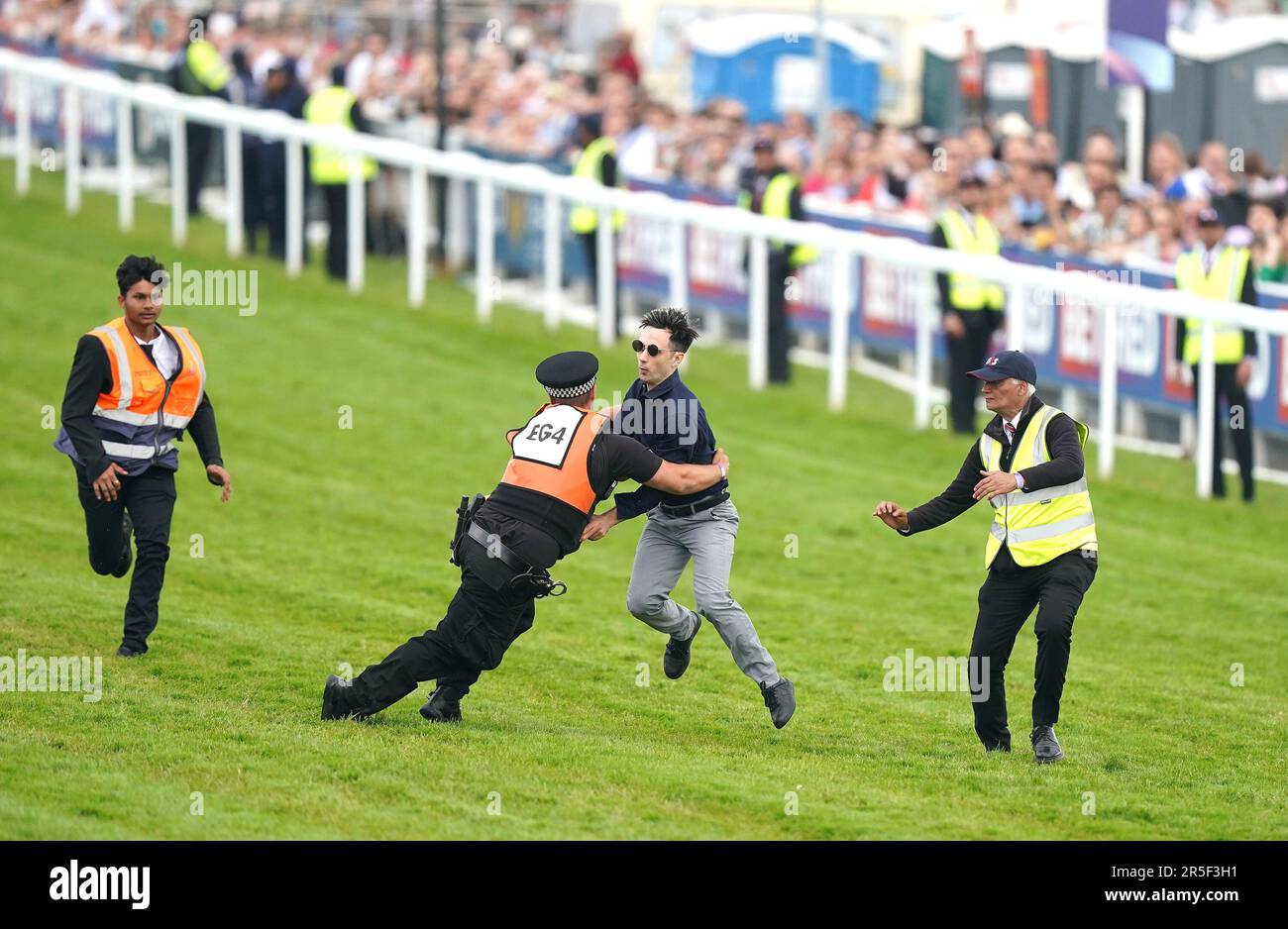 Während des Derby Festivals auf der Rennbahn Epsom Downs, Epsom, werden die Polizei und die Stewards auf dem Betfred Derby von einem Demonstranten angegriffen. Foto: Samstag, 3. Juni 2023. Stockfoto