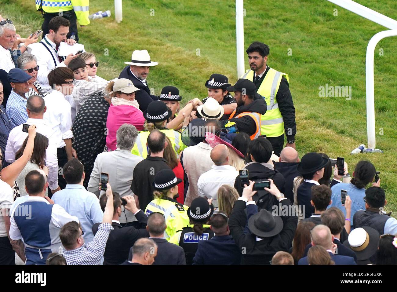 Ein Zuschauer wird während des Betfair Derby Festivals auf der Epsom Downs Racecourse, Epsom, von der Polizei in der Menge festgehalten. Foto: Samstag, 3. Juni 2023. Stockfoto