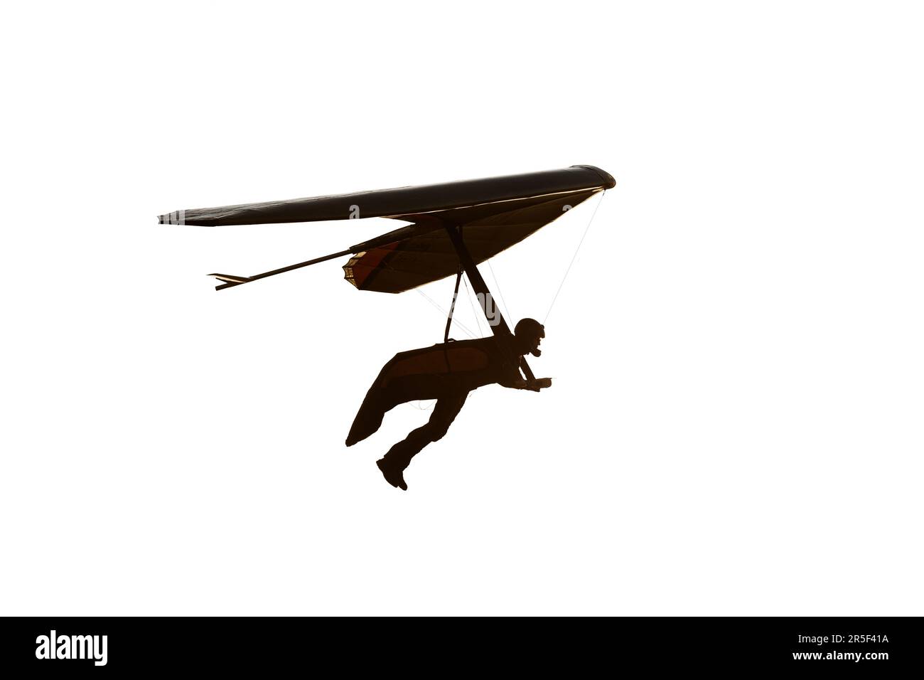 Die Silhouette des echten Drachenfliegers ist in Weiß isoliert. Pilot mit den Beinen aus dem Gurtzeug Stockfoto