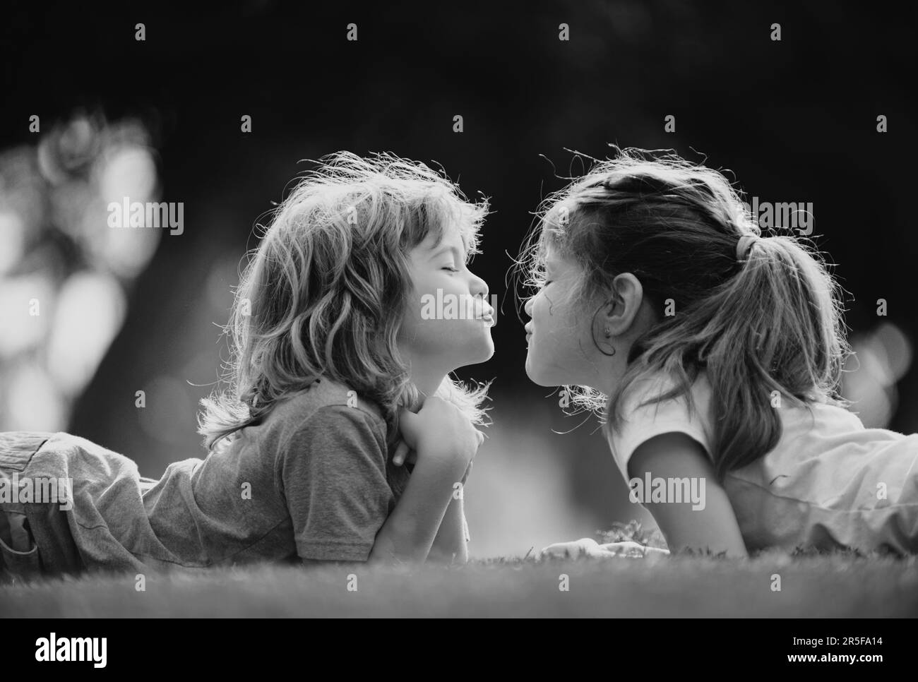 Beziehungen zu Kindern. Nette Liebe. Kleine Kinder küssen im Freien im Park. Stockfoto