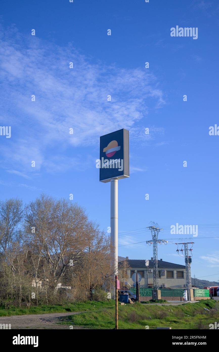 Leuchtender Wegweiser zur Repsol-Tankstelle bei Tag senkrecht mit blauem Himmel und Wolken Stockfoto