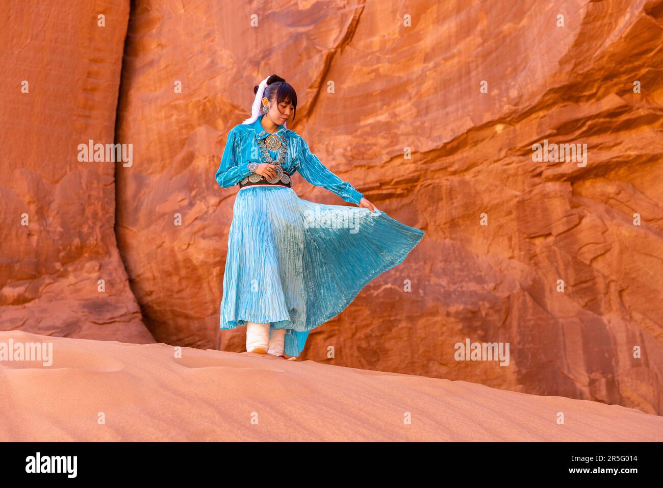 Junge indianische Navajo-Frau am Big Hogan Arch im Monument Valley Navajo Tribal Park, Arizona, USA Stockfoto