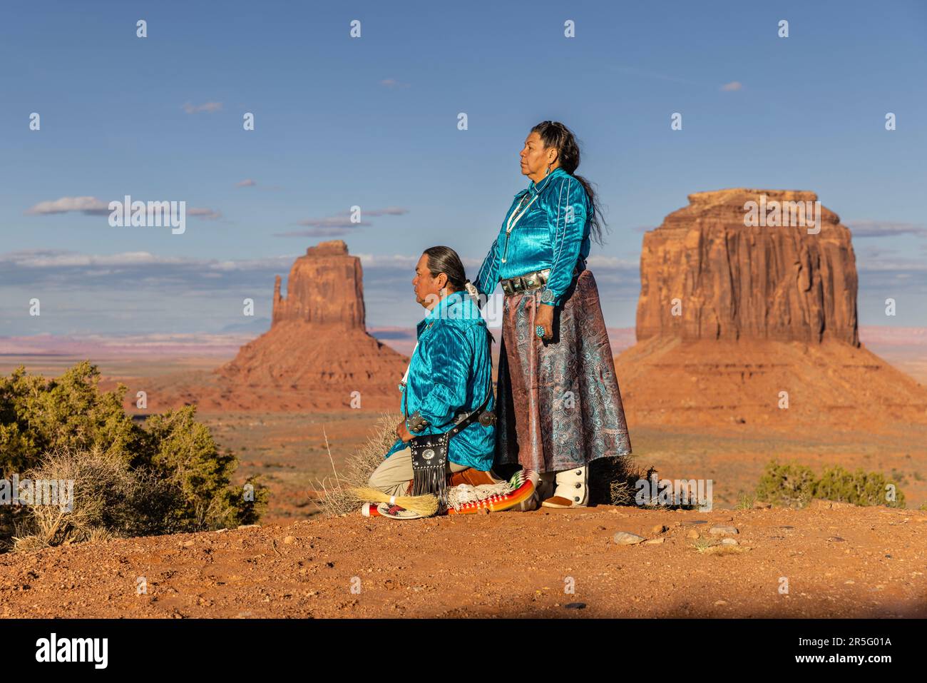 Ein amerikanisches Indianer-Navajo-Paar, das sich während des Sonnenuntergangs im Monument Valley Navajo Tribal Park, Arizona, USA, posiert Stockfoto