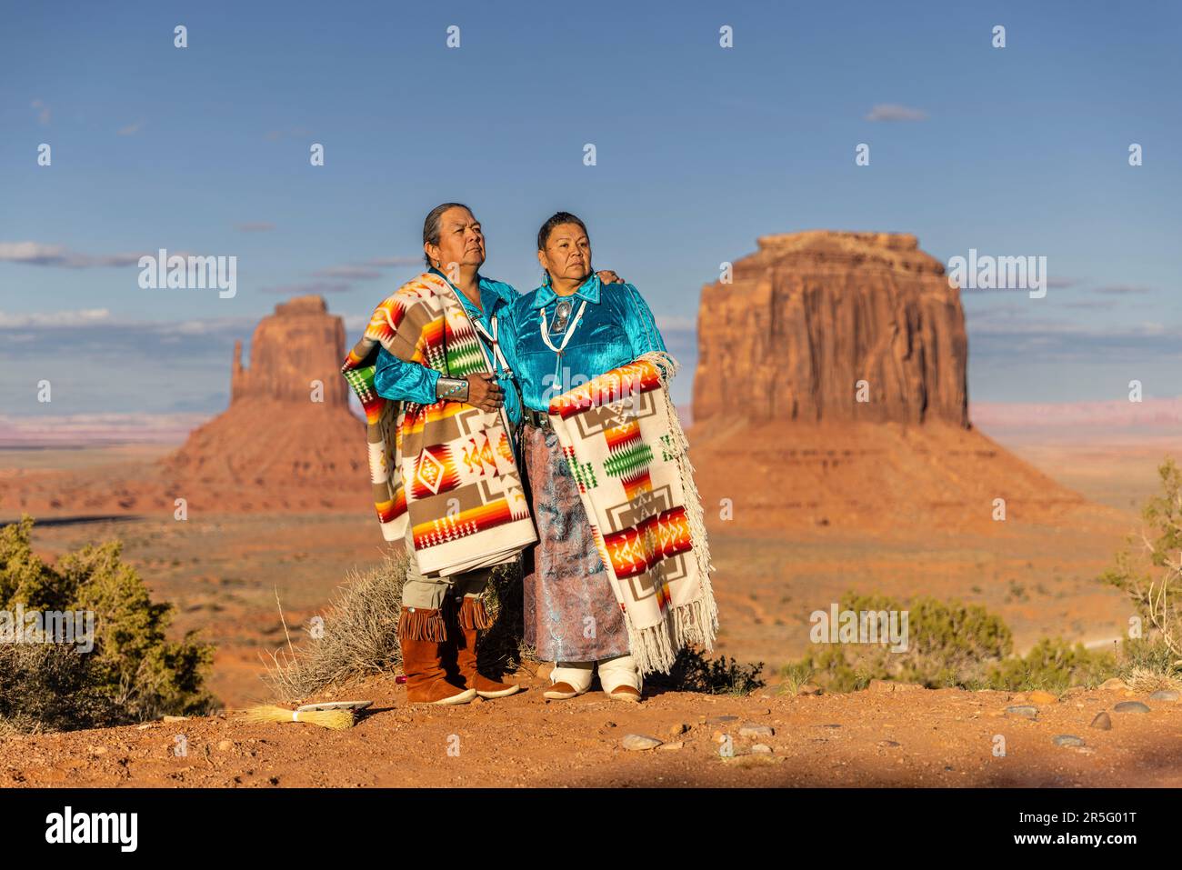 Ein amerikanisches Indianer-Navajo-Paar, das sich während des Sonnenuntergangs im Monument Valley Navajo Tribal Park, Arizona, USA, posiert Stockfoto