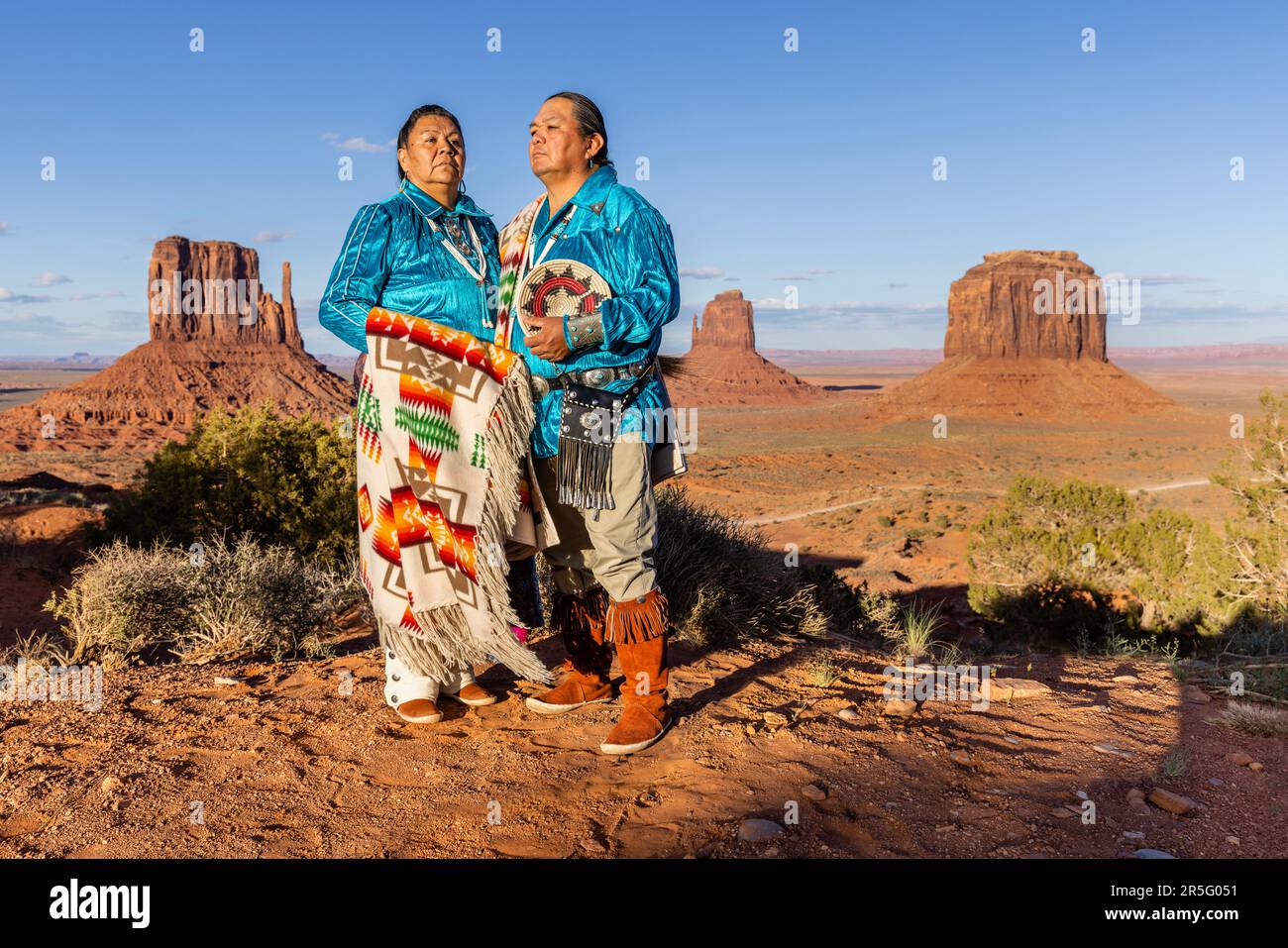 Ein amerikanisches Indianer-Navajo-Paar, das sich während des Sonnenuntergangs im Monument Valley Navajo Tribal Park, Arizona, USA, posiert Stockfoto