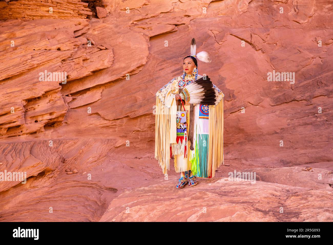 Eine amerikanische Navajo-Frau im Honeymoon Arch im Mystery Valley im Monument Valley Navajo Tribal Park, Arizona, USA Stockfoto