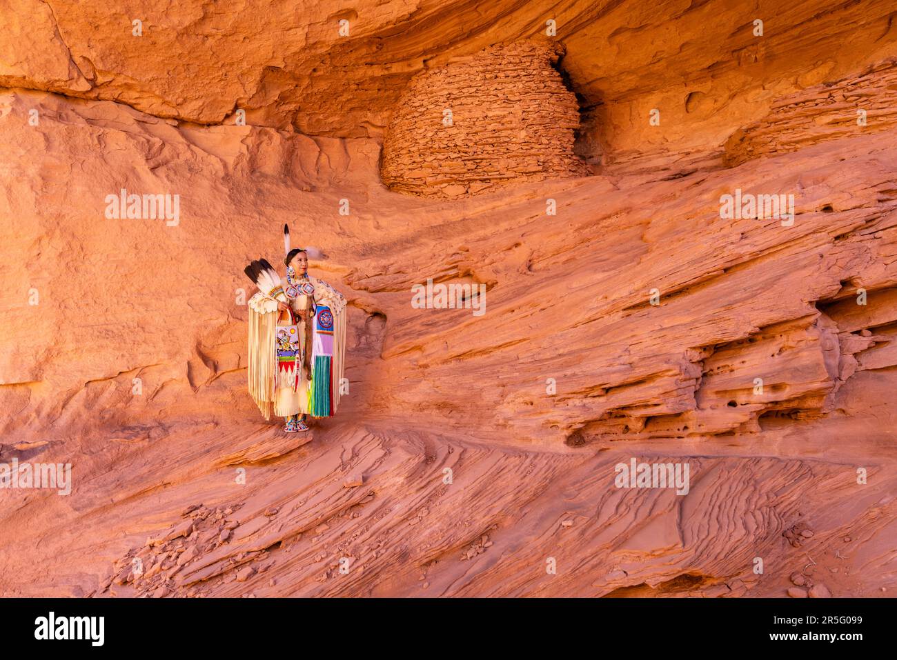 Eine amerikanische Navajo-Frau im Honeymoon Arch im Mystery Valley im Monument Valley Navajo Tribal Park, Arizona, USA Stockfoto